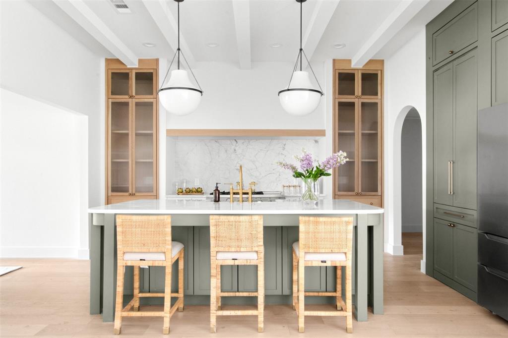 a white kitchen with cabinets and chairs