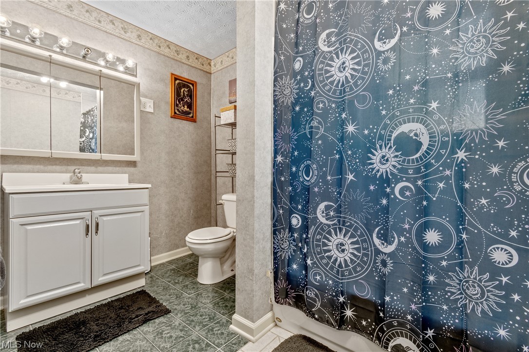 869 Reed Avenue Akron, OH 44306 - Photo 16 of 25 Bathroom with tile floors, toilet, vanity, and a textured ceiling
