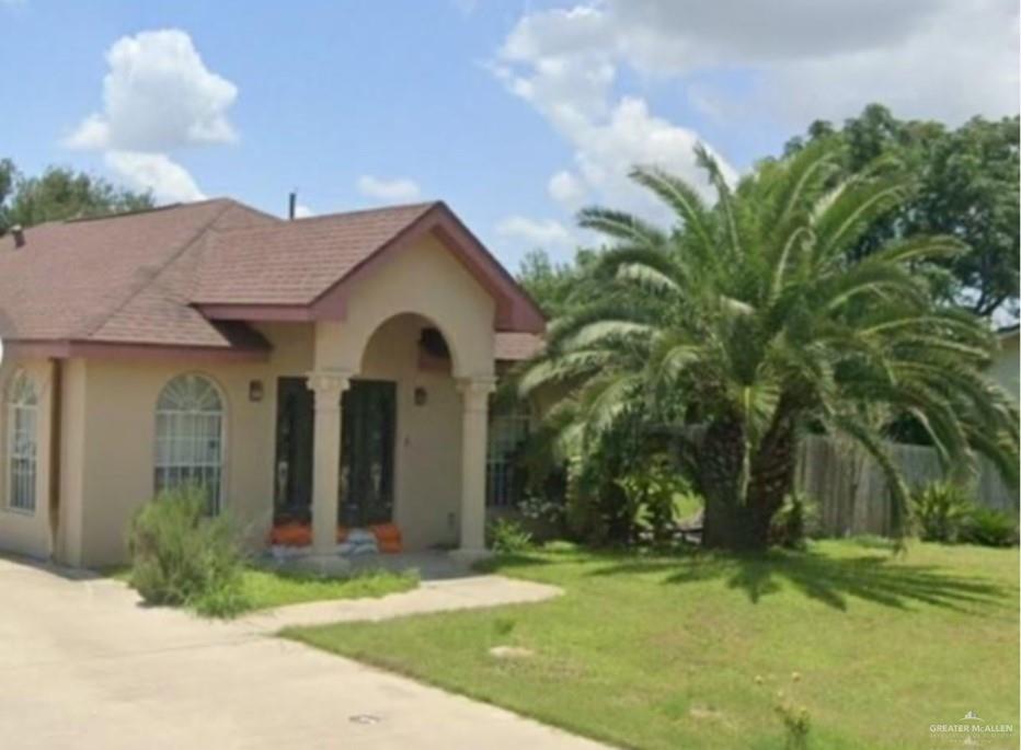 a view of a white house with a big yard and potted plants