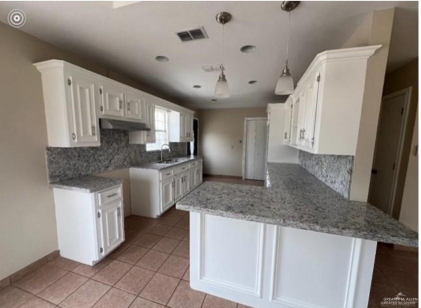 310 Adams Avenue Alton, TX 78573 - Photo 7 of 13 a kitchen with stainless steel appliances granite countertop a sink stove and refrigerator
