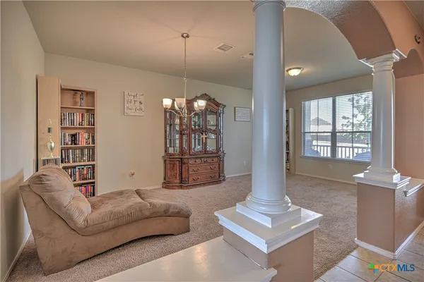 a living room with furniture a window and a chandelier