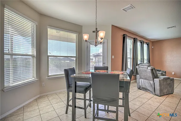 a dining room with furniture and large windows