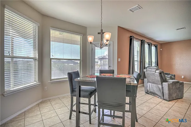 a dining room with furniture and large windows