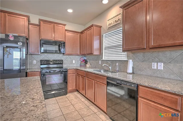 a kitchen with stainless steel appliances granite countertop a sink stove and cabinets