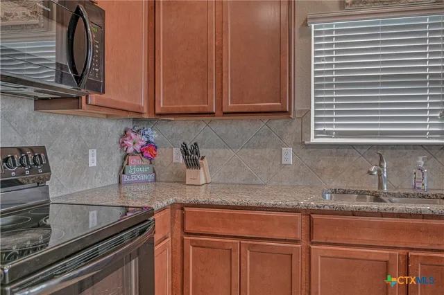 a kitchen with granite countertop stainless steel appliances sink and cabinets