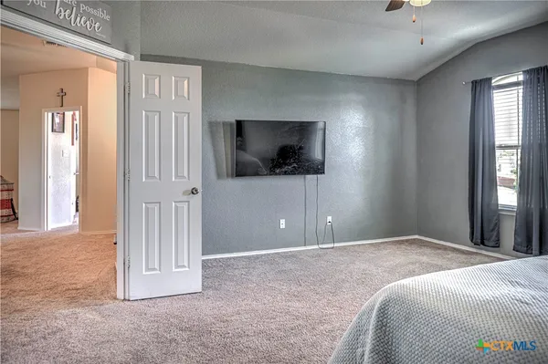 a bedroom with a bed and a flat screen tv