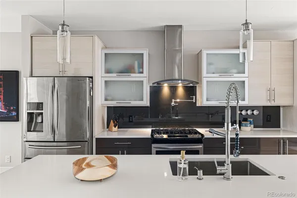 a kitchen with stainless steel appliances granite countertop a table and chairs in it