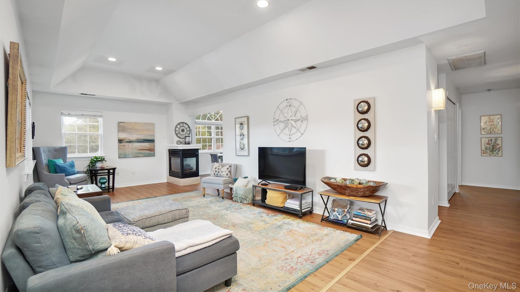 601 Pebble Beach Path Riverhead, NY 11901 - Photo 4 of 20 a living room with furniture a flat screen tv and a fireplace
