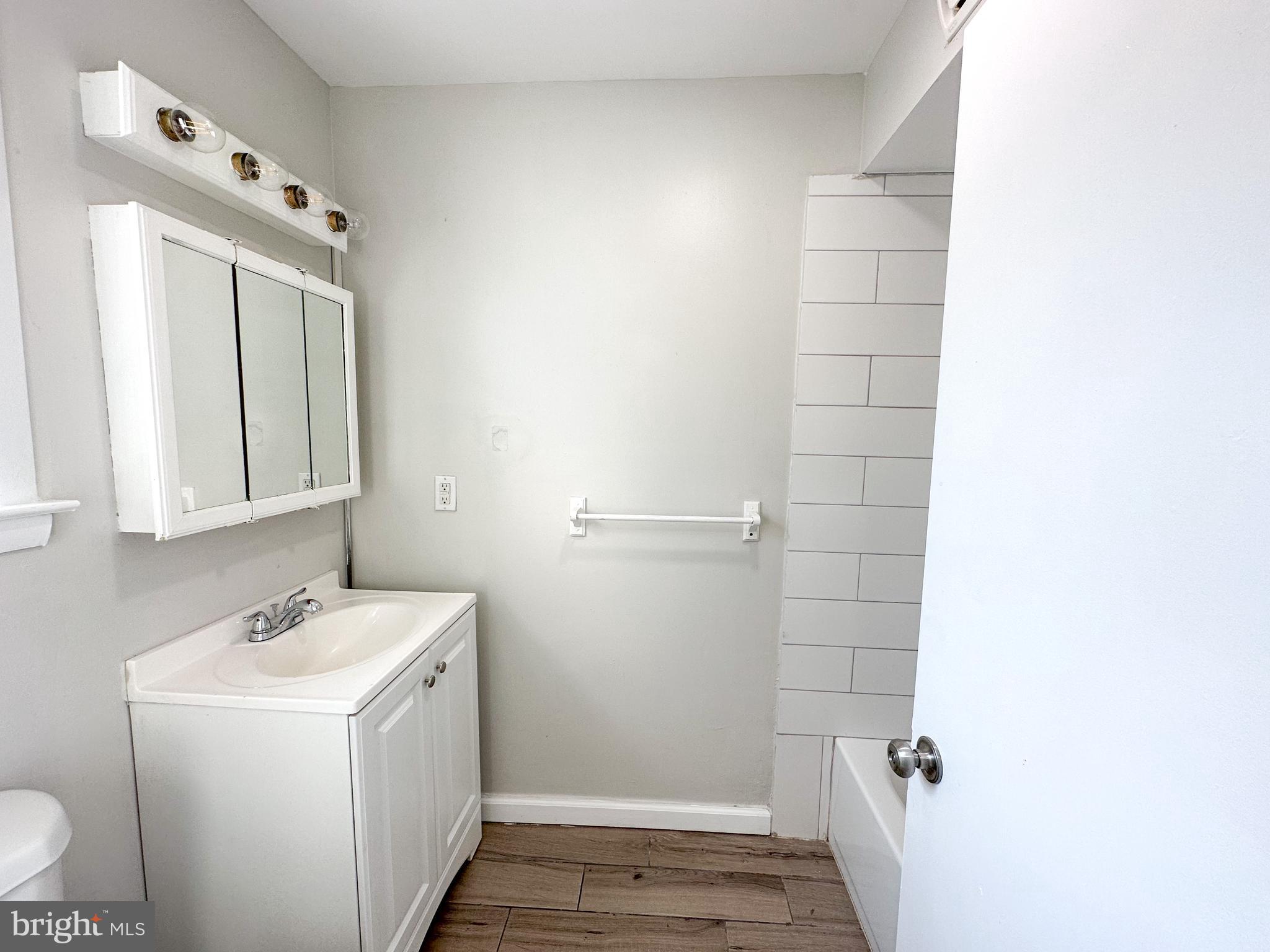 19 Lane Avenue, Unit 1 Gloucester City, NJ 08030 - Photo 10 of 18 a bathroom with a sink and mirror with toilet