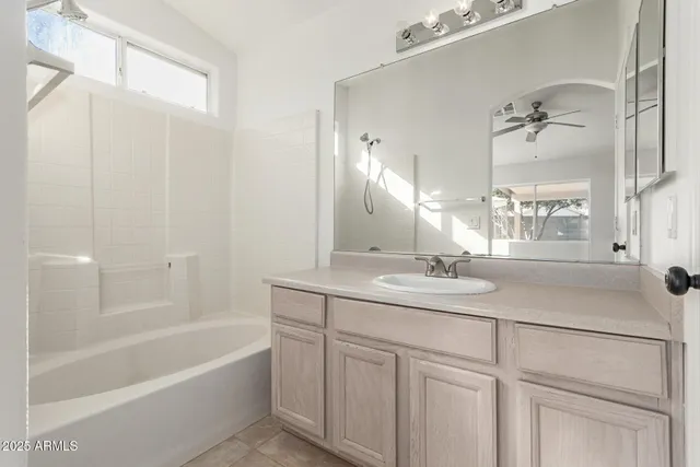a bathroom with a tub sink and mirror
