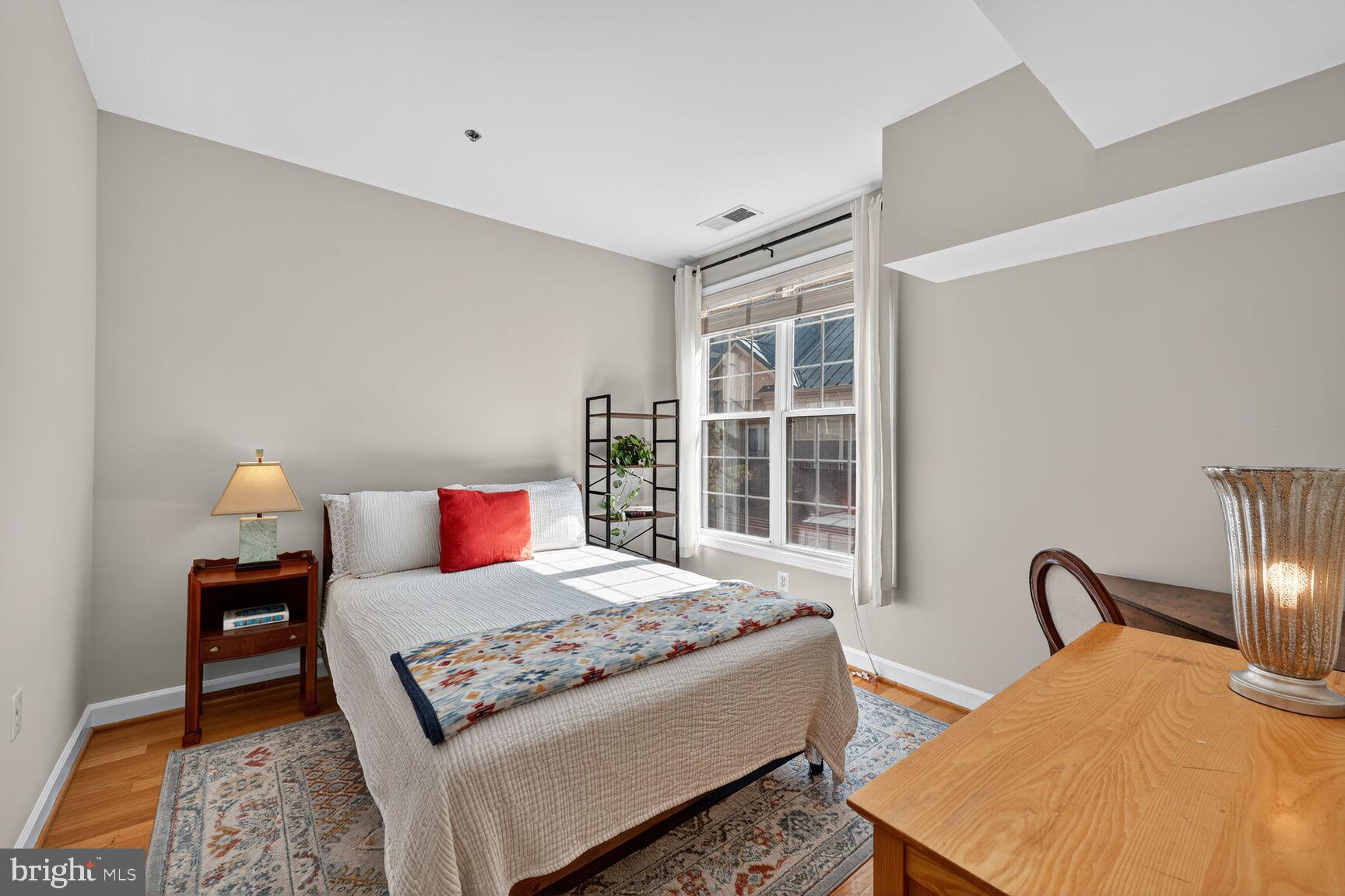 2330 14th Street North, Unit 205 Arlington, VA 22201 - Photo 11 of 29 a bedroom with a bed and wooden floor