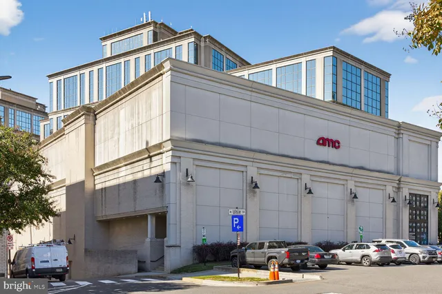 a front view of a building with cars parked