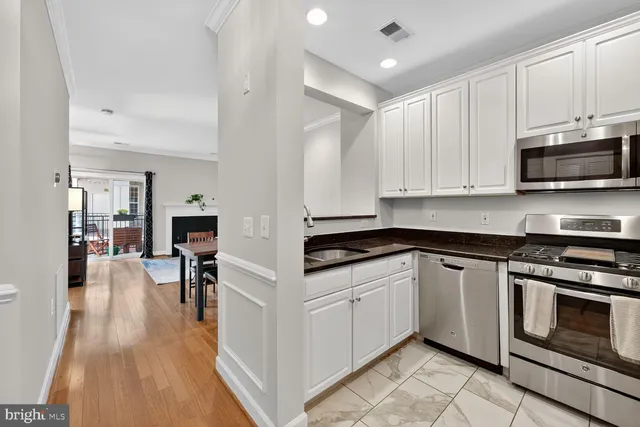 a kitchen with stainless steel appliances white cabinets and sink