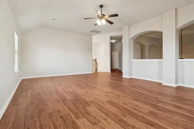 a view of a room with wooden floor and a ceiling fan