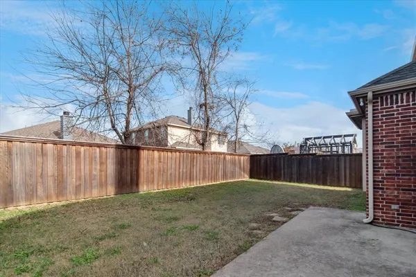 a view of backyard with wooden fence