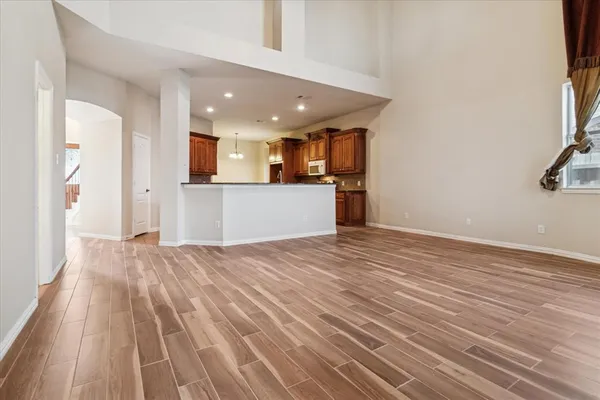 a view of a kitchen with kitchen island wooden floor center island and stainless steel appliances