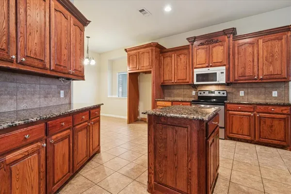a kitchen with stainless steel appliances granite countertop a stove top oven a sink dishwasher and cabinets with wooden floor