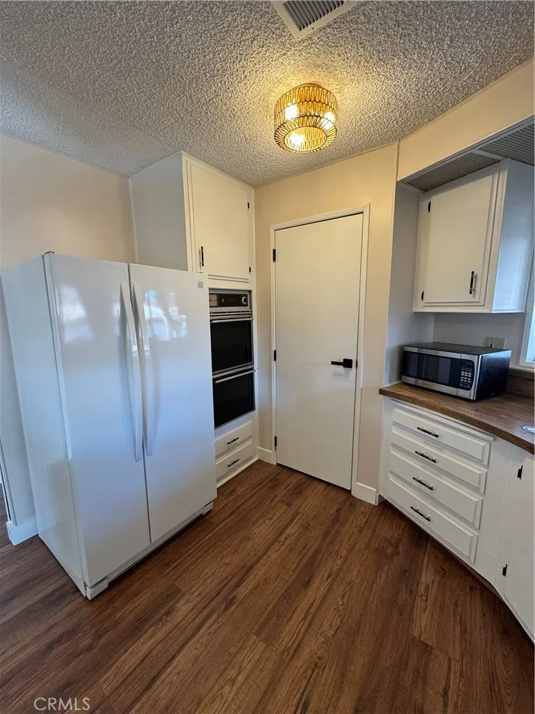 8651 Foothill, Unit 157 Rancho Cucamonga, CA 91730 - Photo 6 of 19 a kitchen with granite countertop cabinets and wooden floor