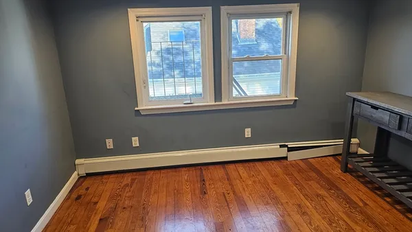 a view of room with window and wooden floor