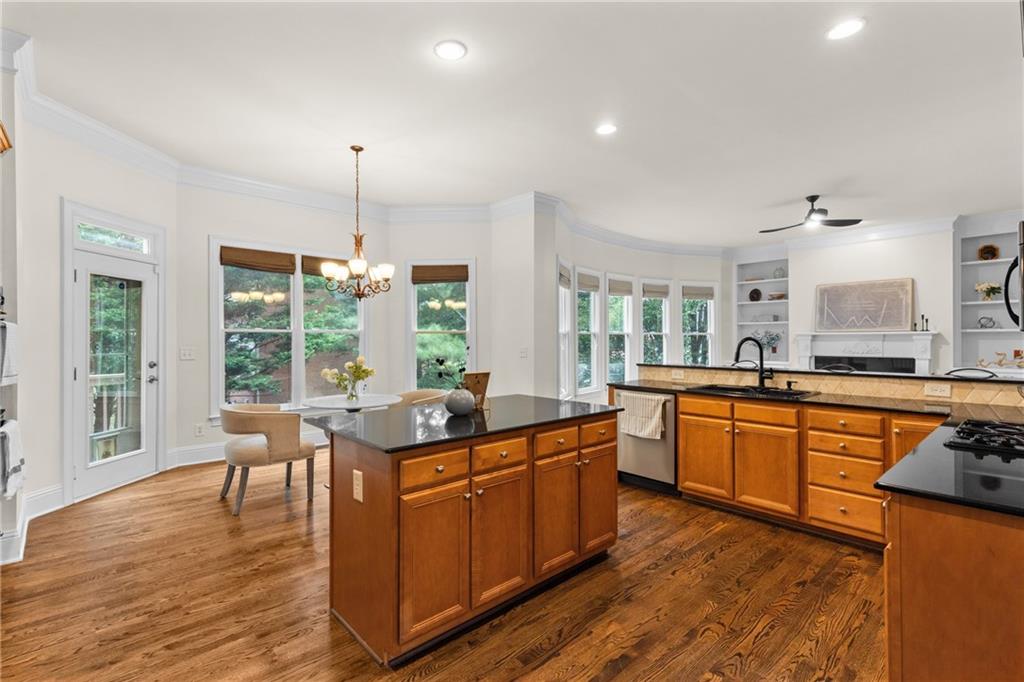 5765 Bailey Ridge Court Duluth, GA 30097 - Photo 14 of 53 a kitchen with stainless steel appliances granite countertop wooden floors and white cabinets