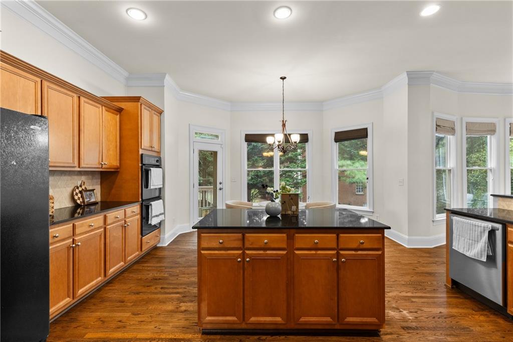 5765 Bailey Ridge Court Duluth, GA 30097 - Photo 15 of 53 a kitchen with stainless steel appliances granite countertop a sink a stove and a wooden floors