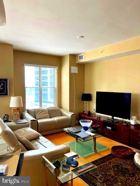 7710 Woodmont Avenue, Unit 911 Bethesda, MD 20814 - Photo 3 of 25 a living room with furniture a flat screen tv and a window