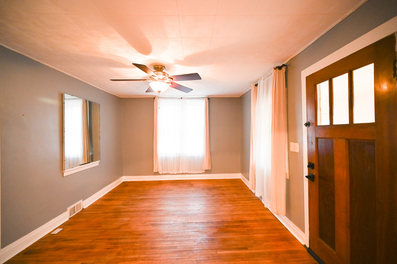 219 South 7th Street DeKalb, IL 60115 - Photo 6 of 30 a view of an empty room with wooden floor and a window