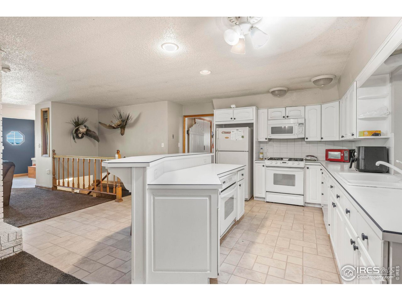32864 County Road 49 Greeley, CO 80631 - Photo 8 of 40 a kitchen with white cabinets and appliances