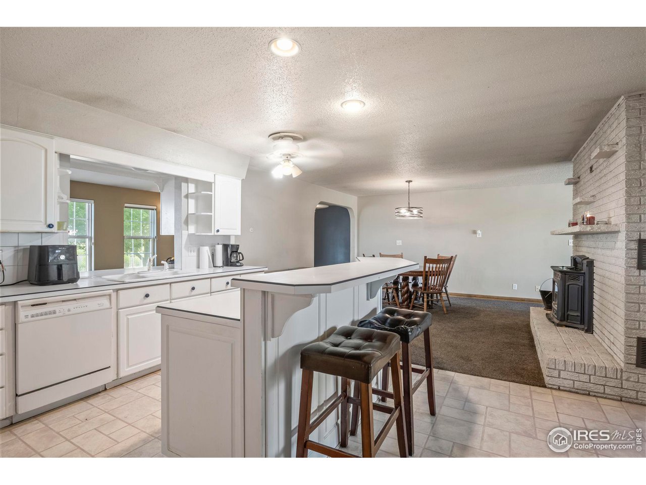 32864 County Road 49 Greeley, CO 80631 - Photo 9 of 40 a open kitchen with stainless steel appliances kitchen island granite countertop a table chairs and a refrigerator
