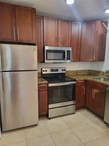 a kitchen with granite countertop cabinets and steel stainless steel appliances