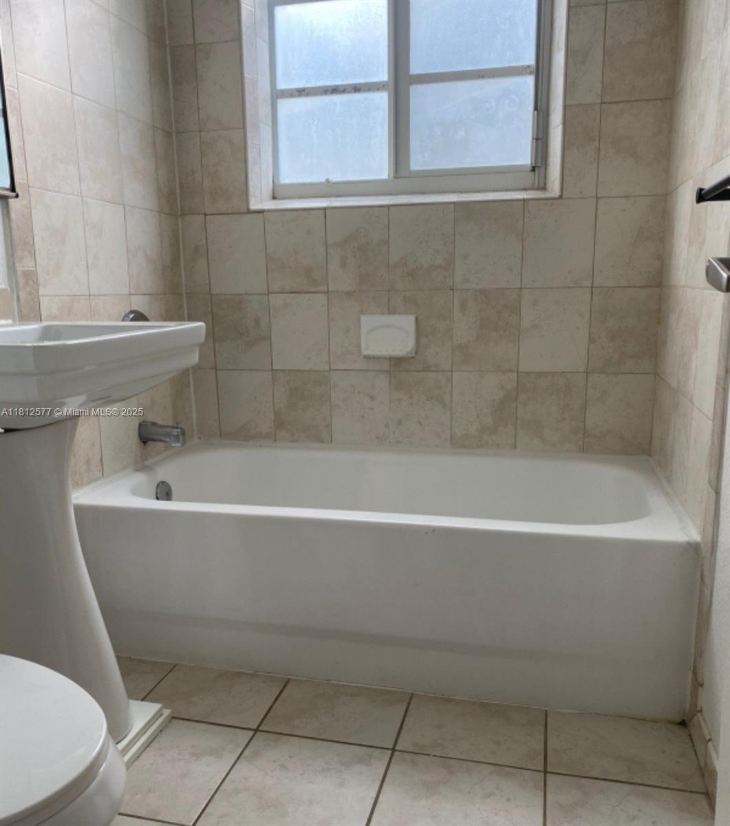 340 84th Street, Unit 2 Miami Beach, FL 33141 - Photo 8 of 10 a white bath tub sitting next to a white toilet