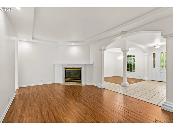 a view of an empty room with window and wooden floor