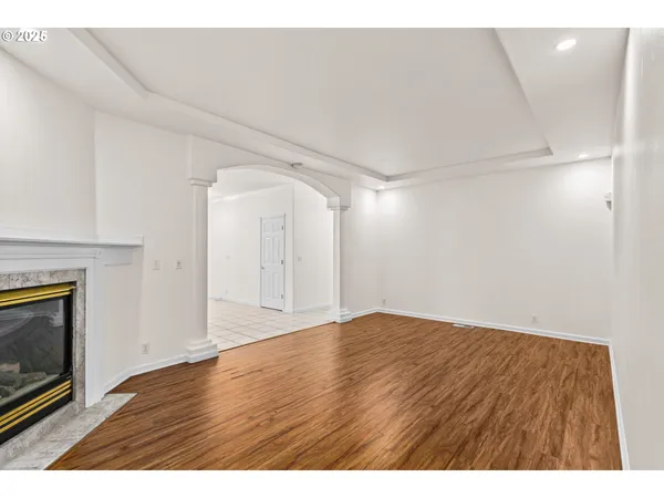 a view of empty room with wooden floor and fireplace