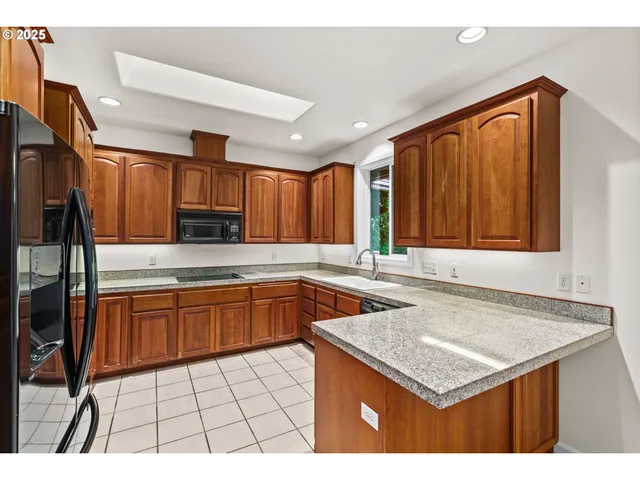 a kitchen with stainless steel appliances granite countertop a sink stove and cabinets