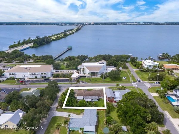 an aerial view of a house with a garden and lake view