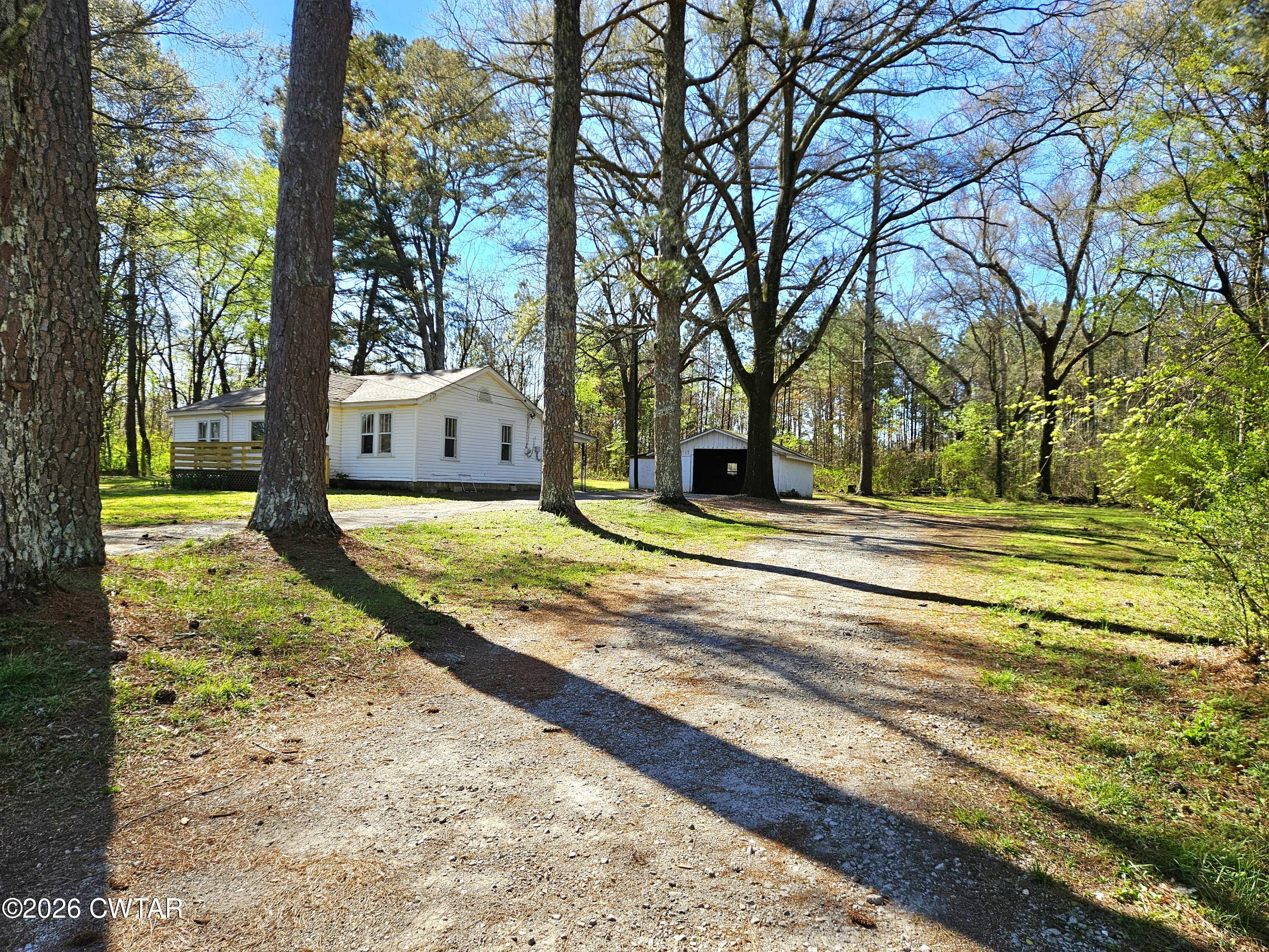 550 Lawrence Switch Road Jackson, TN 38305 - Photo 20 of 25 a yellow house with trees in front of it