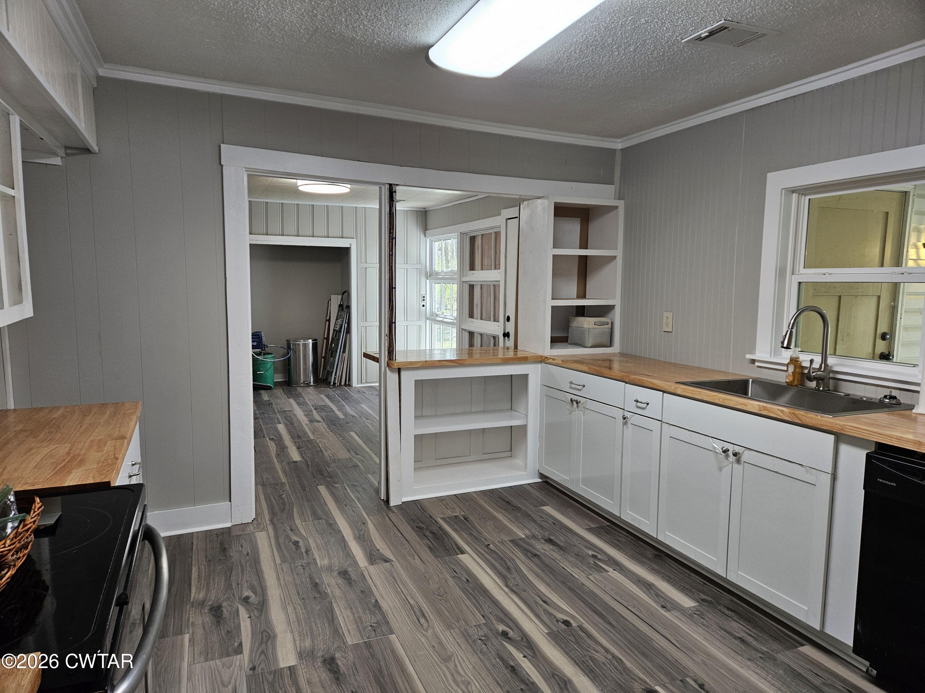 550 Lawrence Switch Road Jackson, TN 38305 - Photo 7 of 25 a kitchen with wooden floors and white cabinets