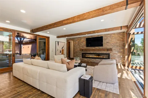 a living room with furniture fireplace and large windows