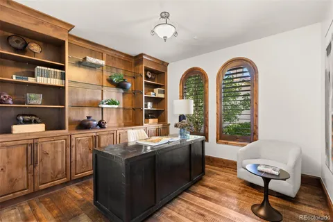 a dining room with furniture a floor to ceiling window and wooden floor