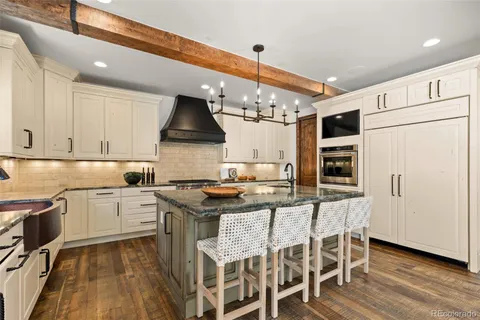 a dining room with wooden floor and chandelier