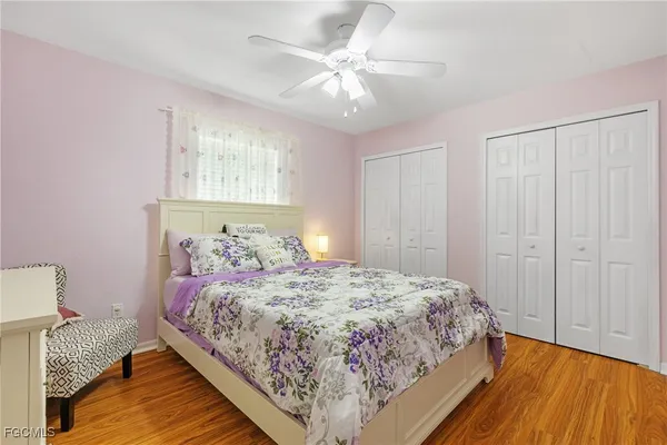 a bedroom with a bed and a dresser with wooden floor