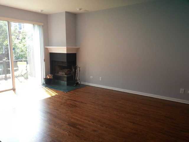 1765 West Altgeld Street, Unit M Chicago, IL 60614 - Photo 3 of 21 an empty room with wooden floor and fireplace