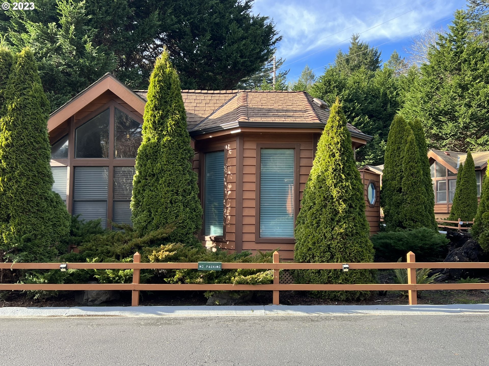 97748 North Bank Chetco River Road, Unit 15 Brookings, OR 97415 - Photo 3 of 48 a front view of a house with a garden