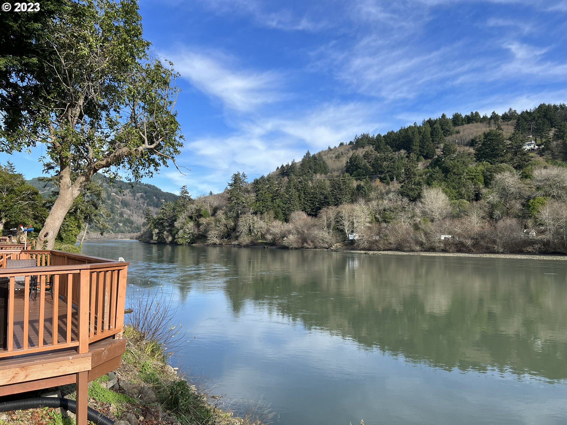 97748 North Bank Chetco River Road, Unit 15 Brookings, OR 97415 - Photo 7 of 48 a view of a lake with a mountain in the background