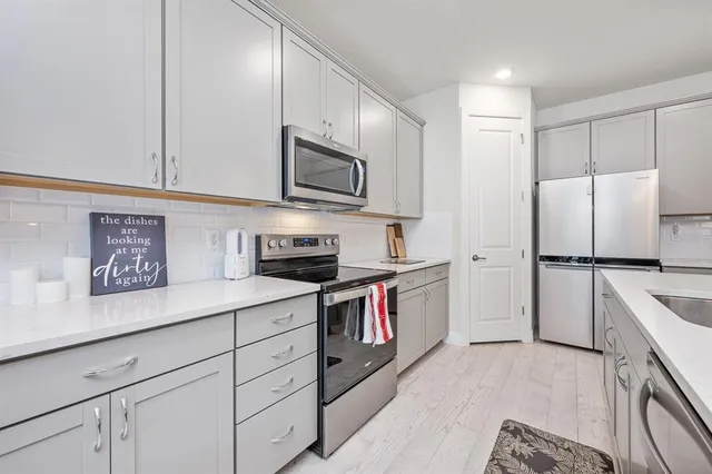 a kitchen with a dining table chairs sink and cabinets