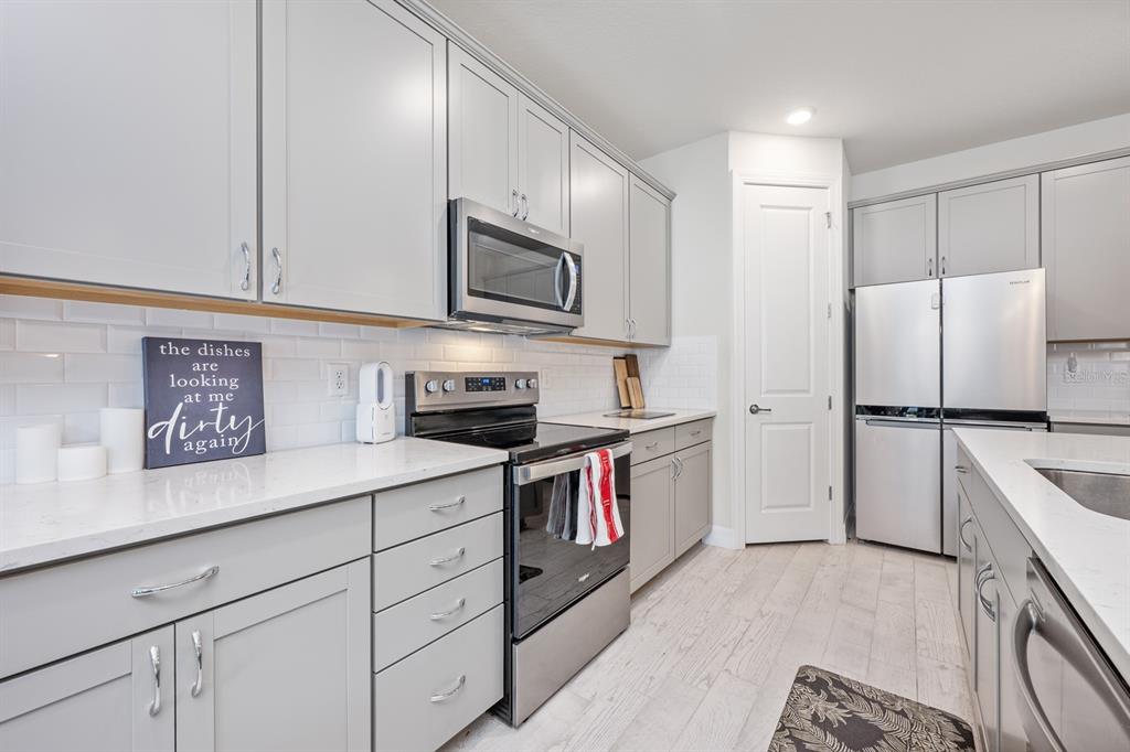 2713 Hilltop Loop Apopka, FL 32712 - Photo 11 of 54 a kitchen with stainless steel appliances granite countertop a refrigerator sink stove microwave and cabinets