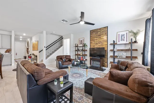 a living room with furniture ceiling fan and a flat screen tv