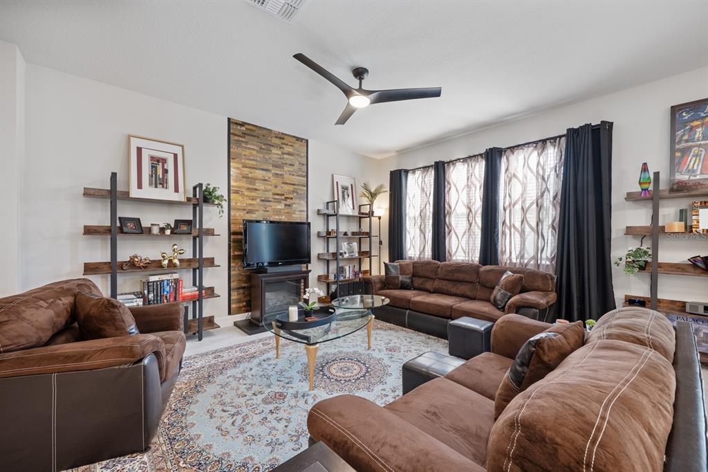 2713 Hilltop Loop Apopka, FL 32712 - Photo 21 of 54 a living room with furniture ceiling fan and a flat screen tv
