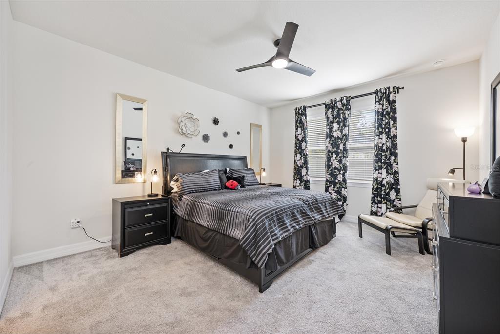 2713 Hilltop Loop Apopka, FL 32712 - Photo 25 of 54 a spacious bedroom with a bed and ceiling fan