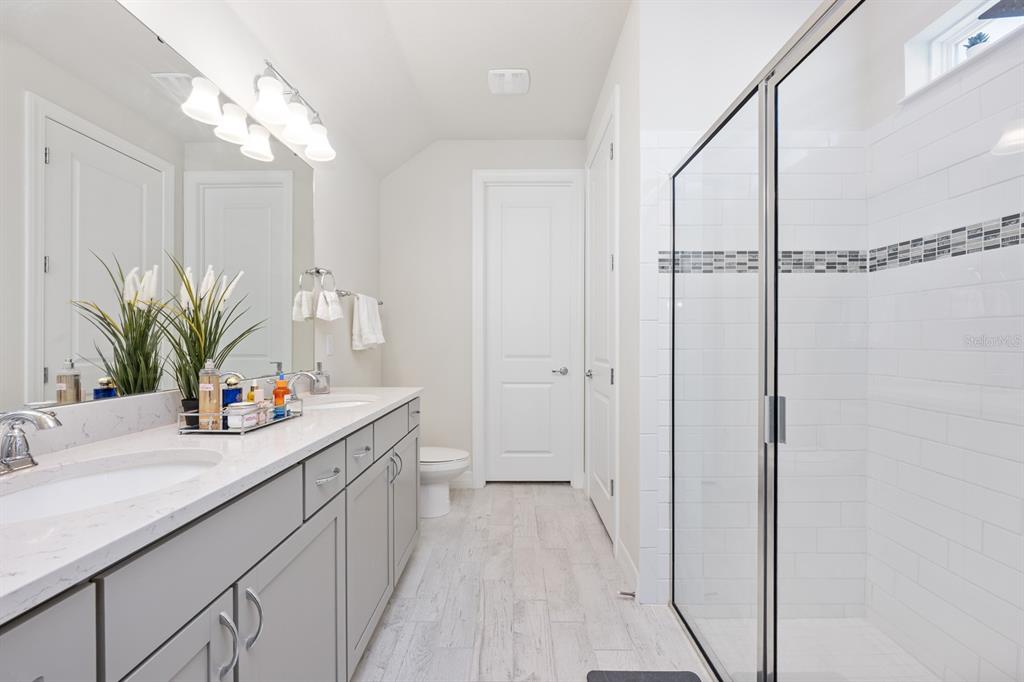 2713 Hilltop Loop Apopka, FL 32712 - Photo 29 of 54 a bathroom with a double vanity sink mirror and shower